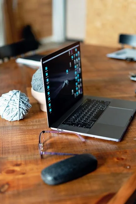 Close-up of hands interacting with a shopping website on a laptop screen indoors.